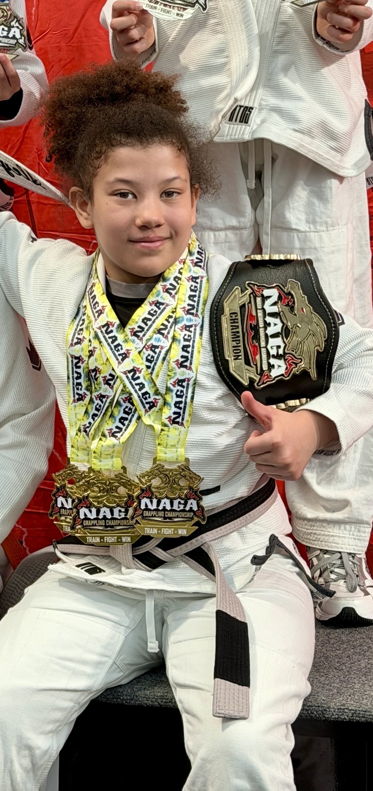 Three golds and the champion belt at NAGA Paris, March 2026.